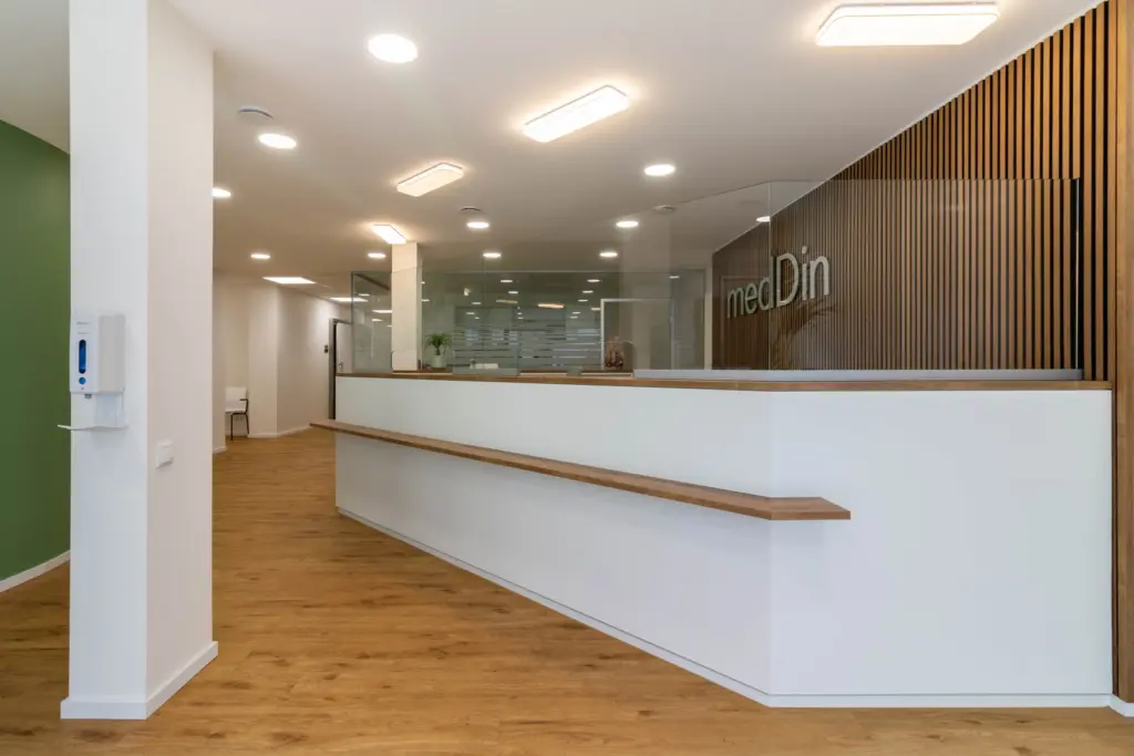 Moderne Empfangstheke in einem hellen, einladenden Büro mit Holzdetails und transparenten Trennwänden.