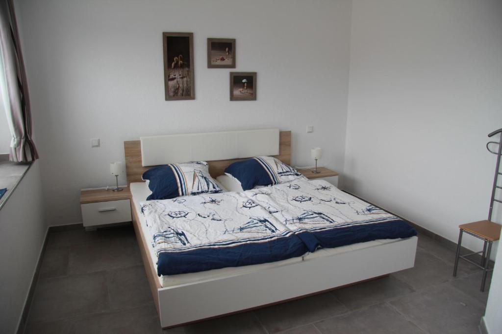 Helles Schlafzimmer mit einem Doppelbett, Nachttischen und Bildern an der Wand.
