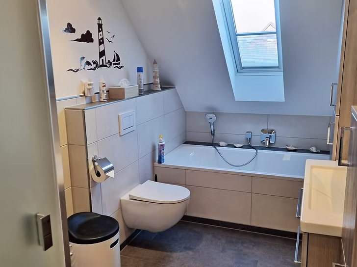 Ein in sanften Erdtönen modern eingerichtetes Badezimmer mit Badewanne.