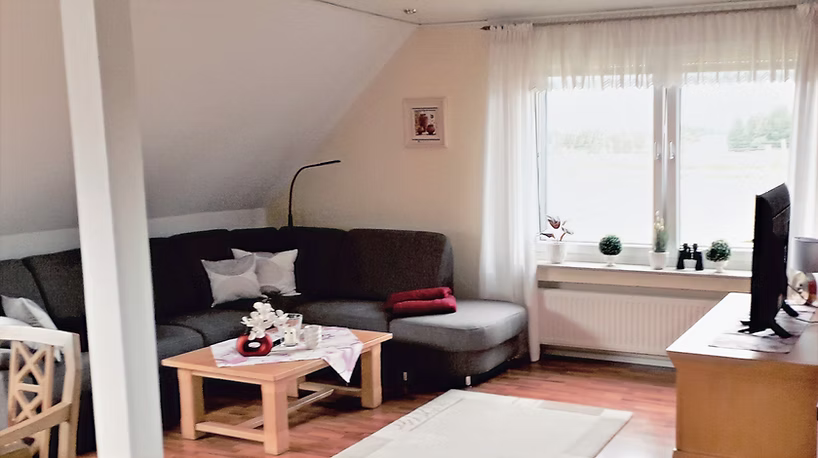 Eine graue Stoffcouch mit einem hellbraunen Sofatisch davor.
