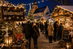Beleuchteter Wintermarkt mit Ständen, Weihnachtsbaum und Menschen in warmer Kleidung, umgeben von festlicher Dekoration.